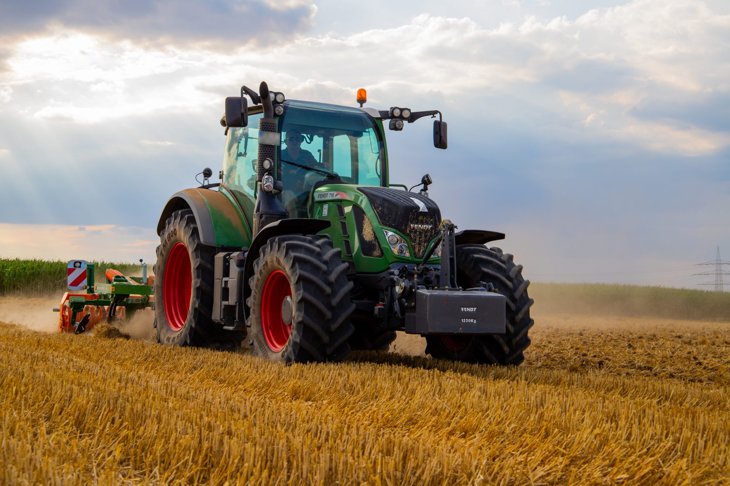 Green tractor plowing the fields