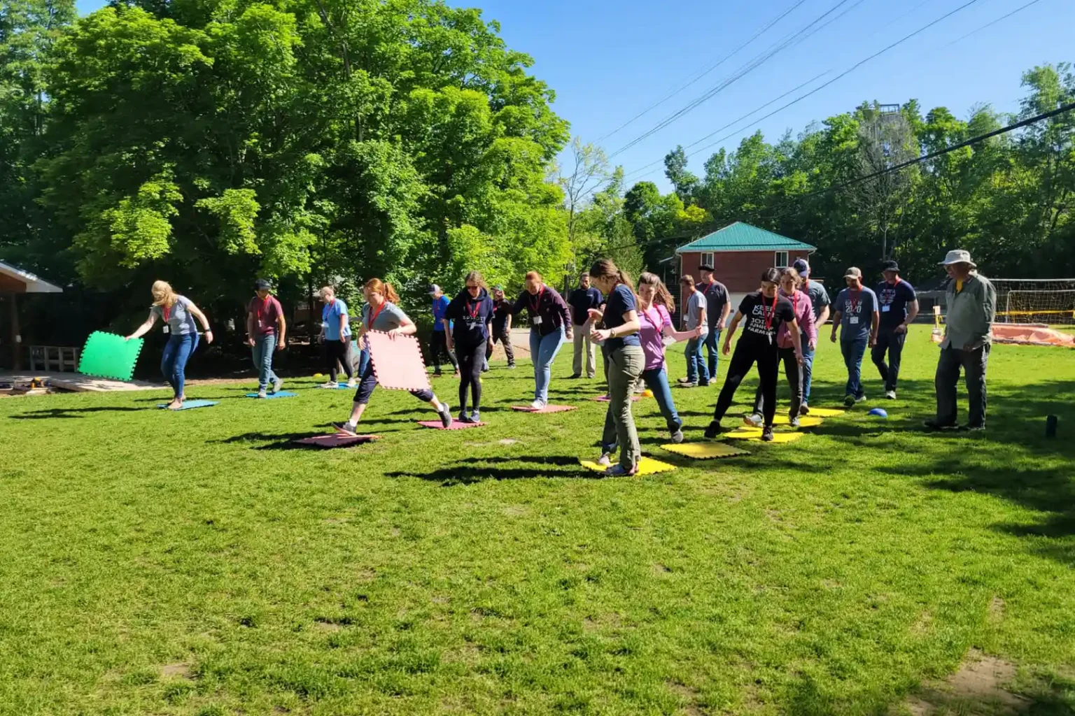 Junior Farmers participants collaborate on an outdoor team-building activity using colourful foam mats during Leadership Camp.